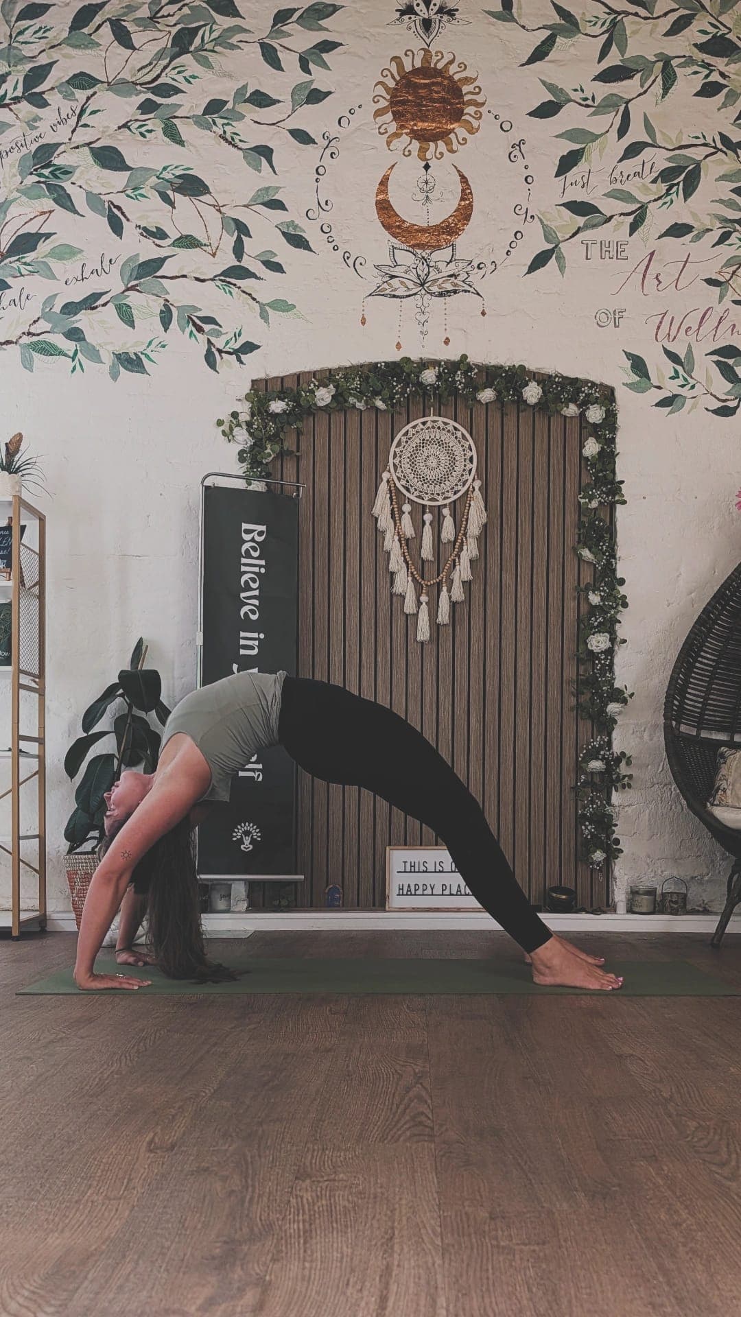 Han arching backwards on the mat beneath the sun and moon mural